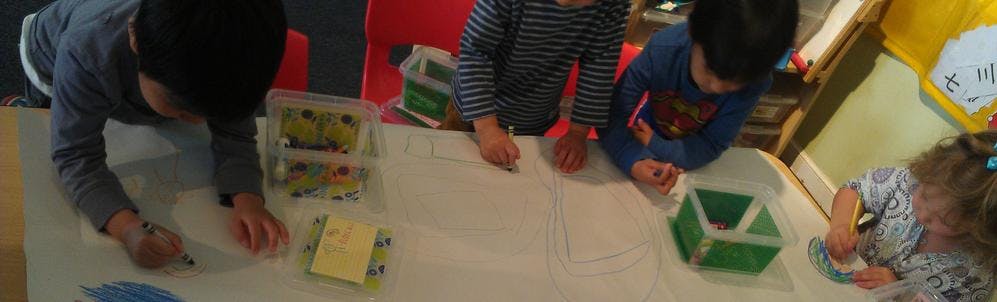 Children drawing and playing with blocks at a table