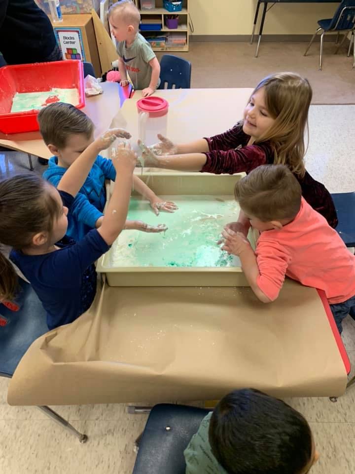 Children playing with water in a sensory bin