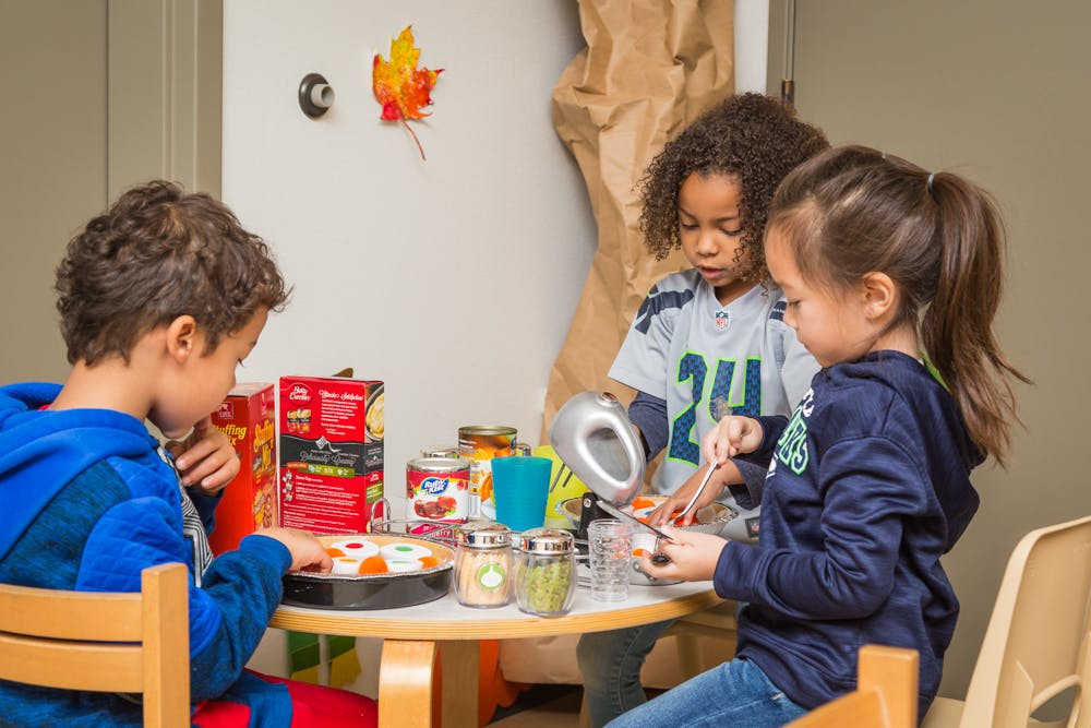 Three children at a table with craft supplies