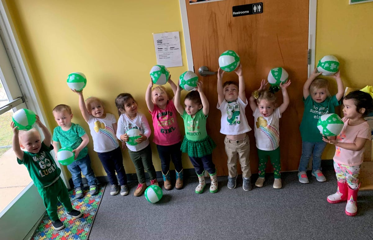 Group of children holding green and white balls