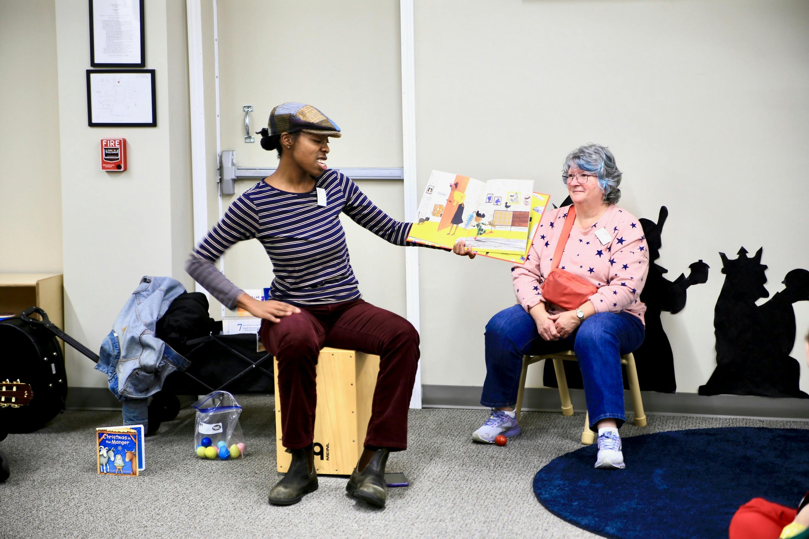 Person reading a children's book to an adult