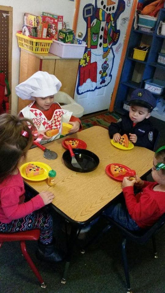 Children playing with toy food at a table