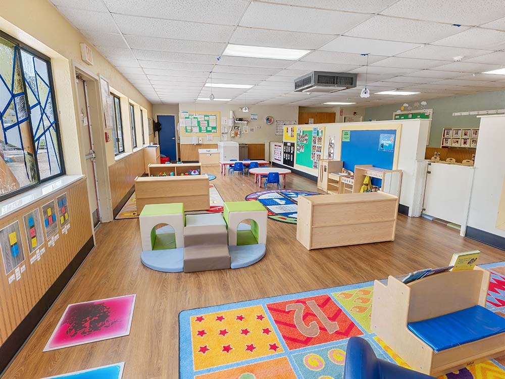 Empty colorful children's classroom with play mats and small furniture