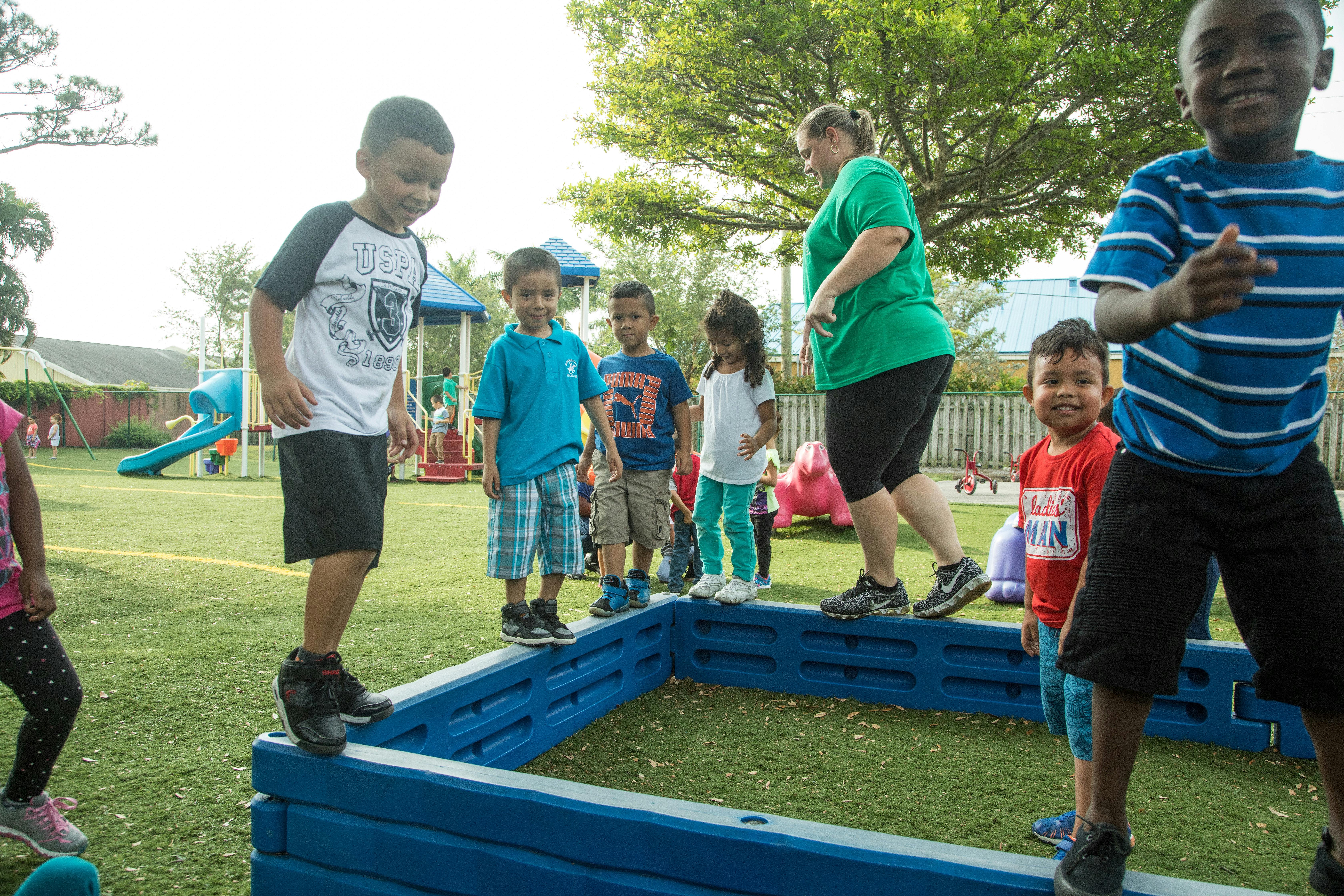 Children and an adult playing on a playground