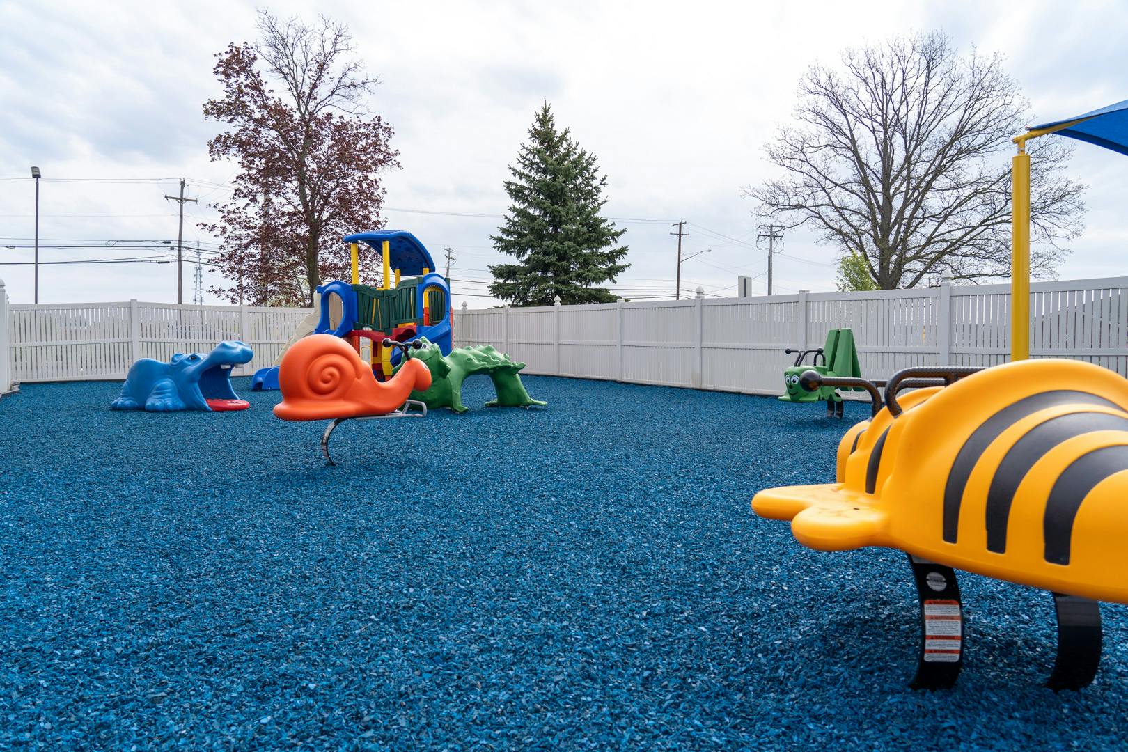 Outdoor playground with blue ground and various colorful play equipment