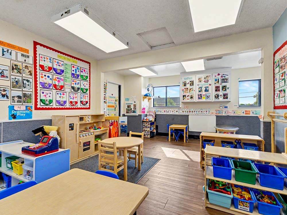 Empty classroom with child-sized furniture and colorful wall decorations
