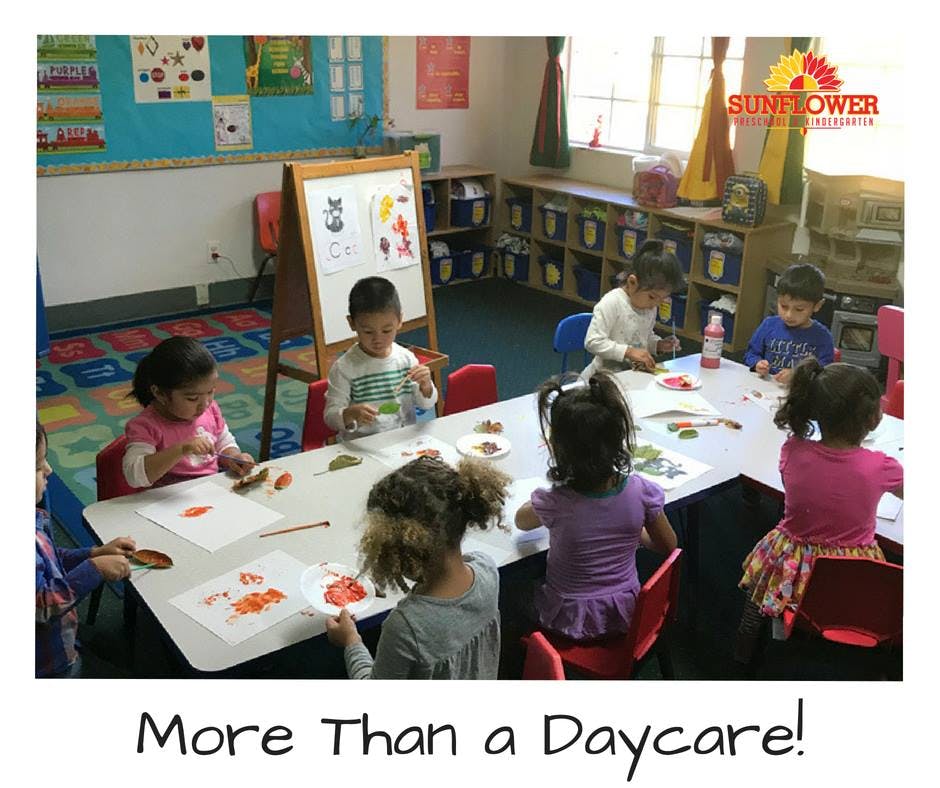 Children sitting at tables in a classroom, engaged in an activity