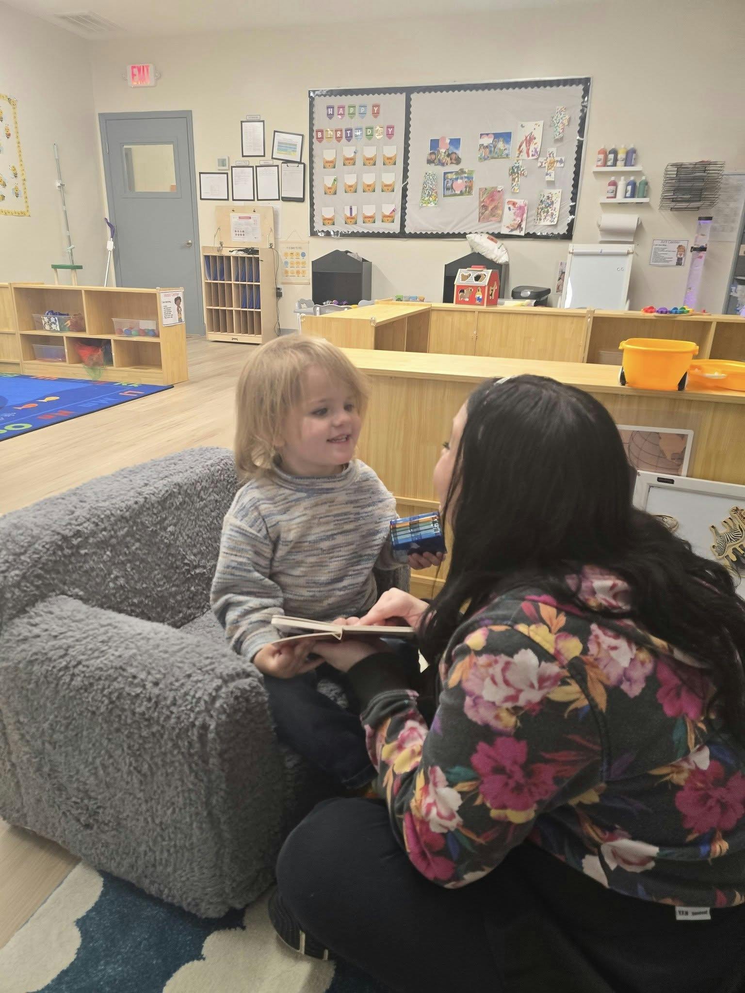 Adult and child looking at a book in a classroom