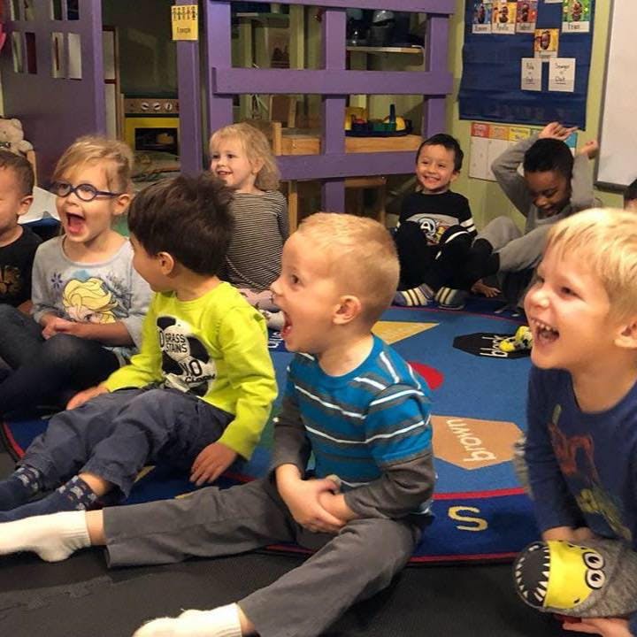 Group of children sitting on the floor in a classroom
