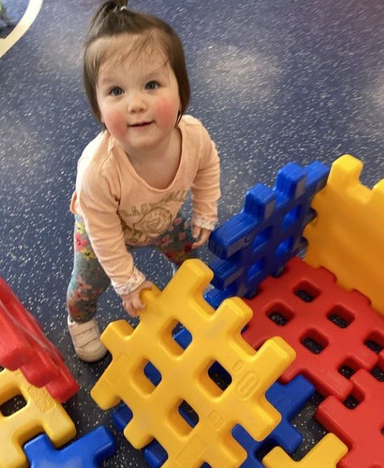 Child playing with large colorful interlocking blocks