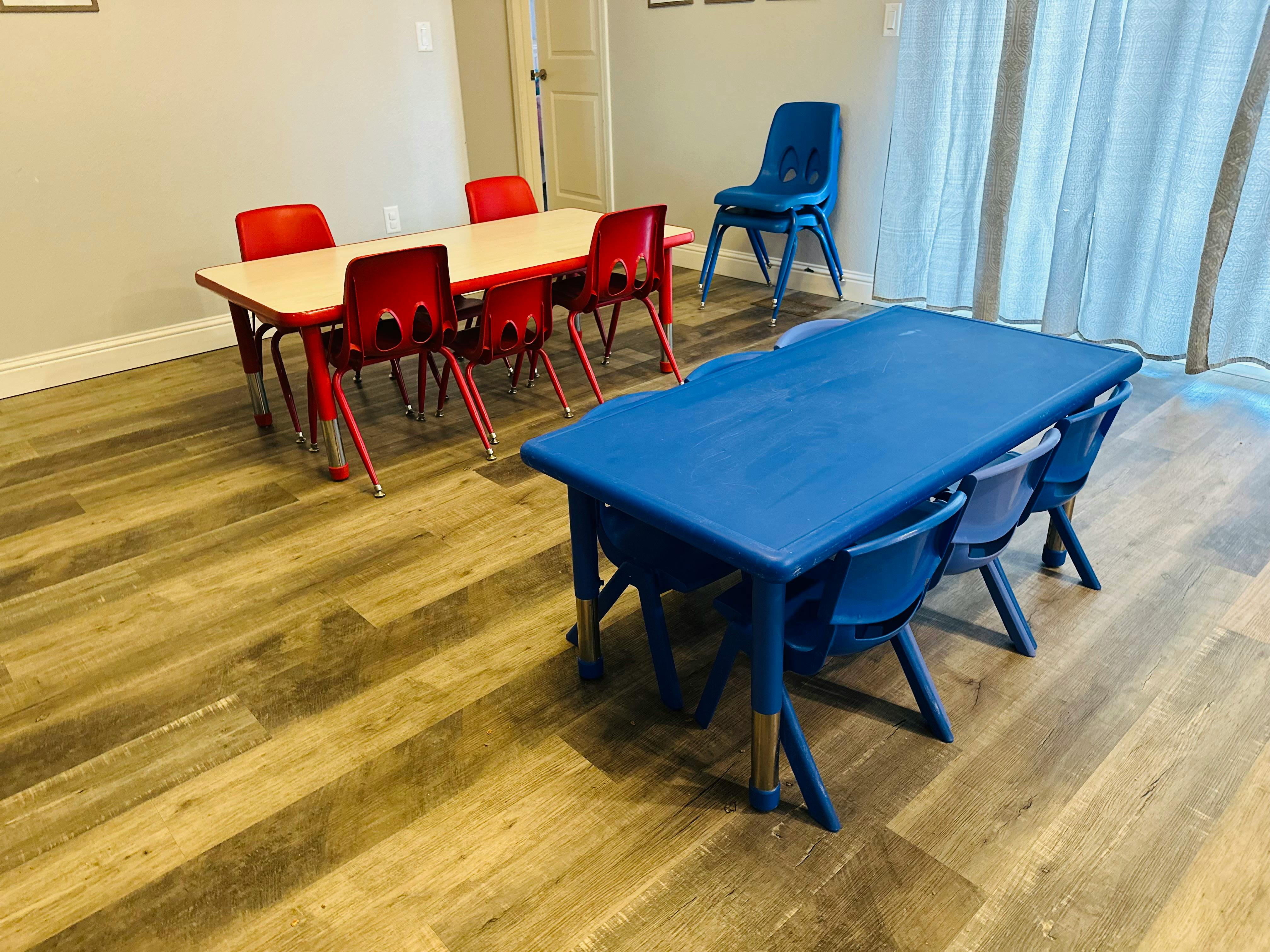 Classroom with small red and blue tables and chairs