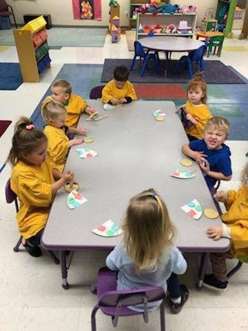 Children sitting at a table in a classroom