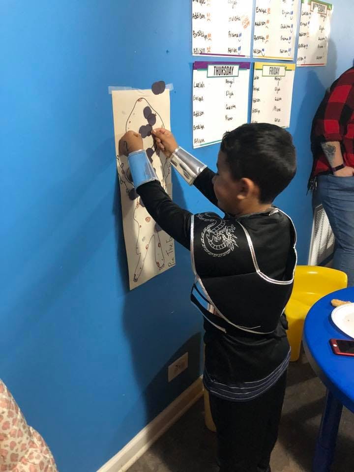 Child in costume playing a game on a wall