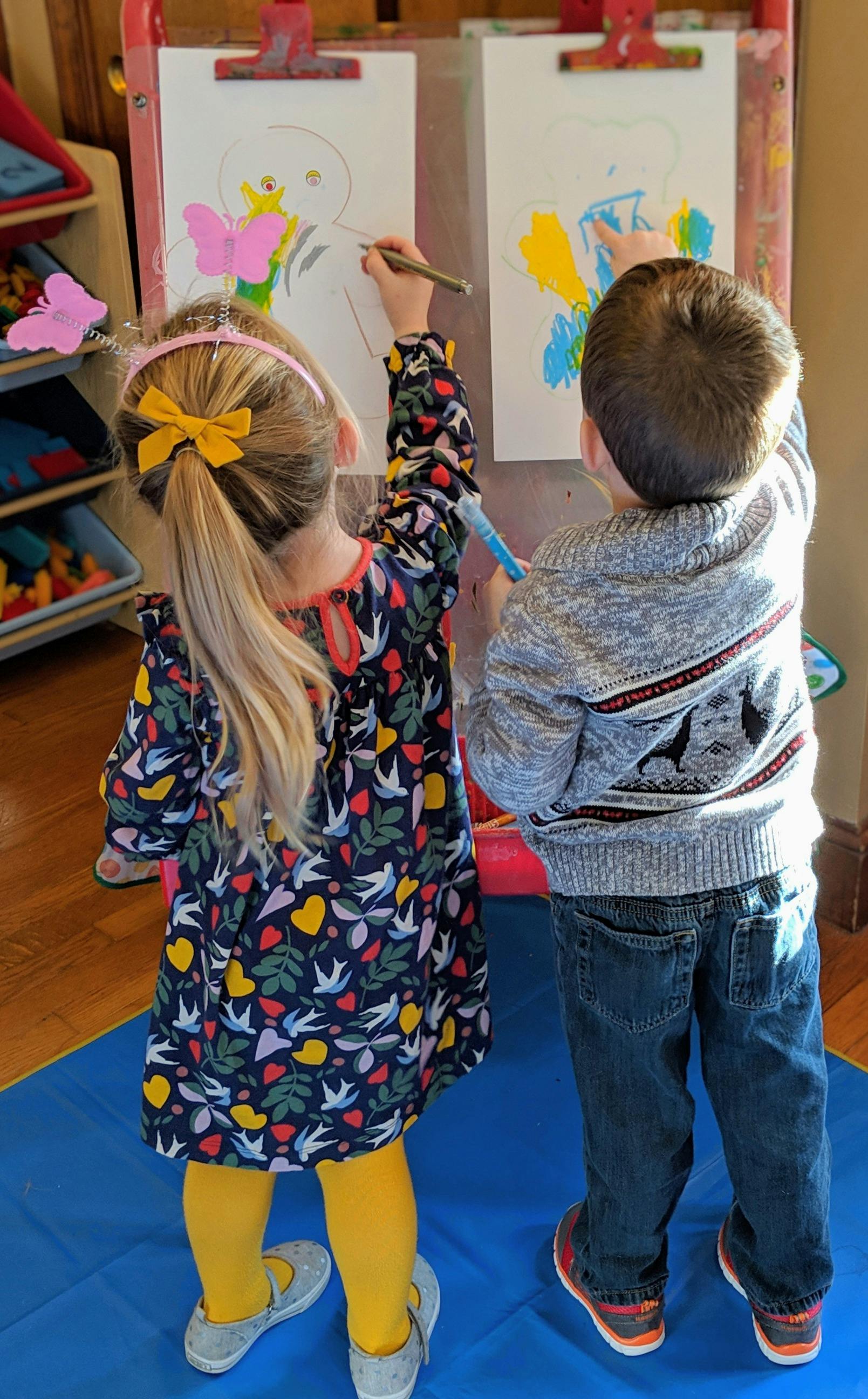 Two children painting at an easel