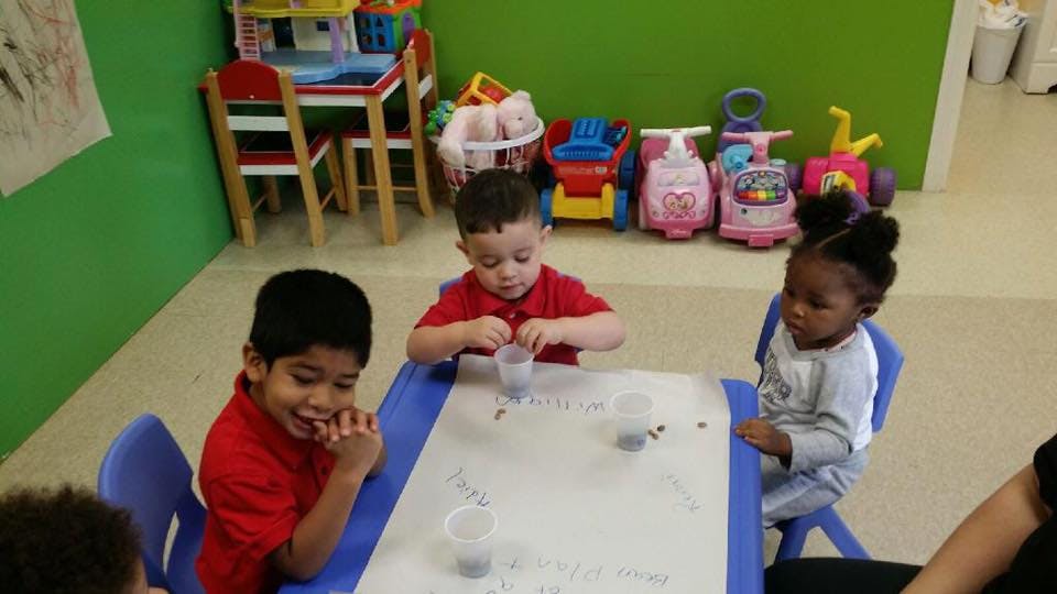 Three children at a table with cups