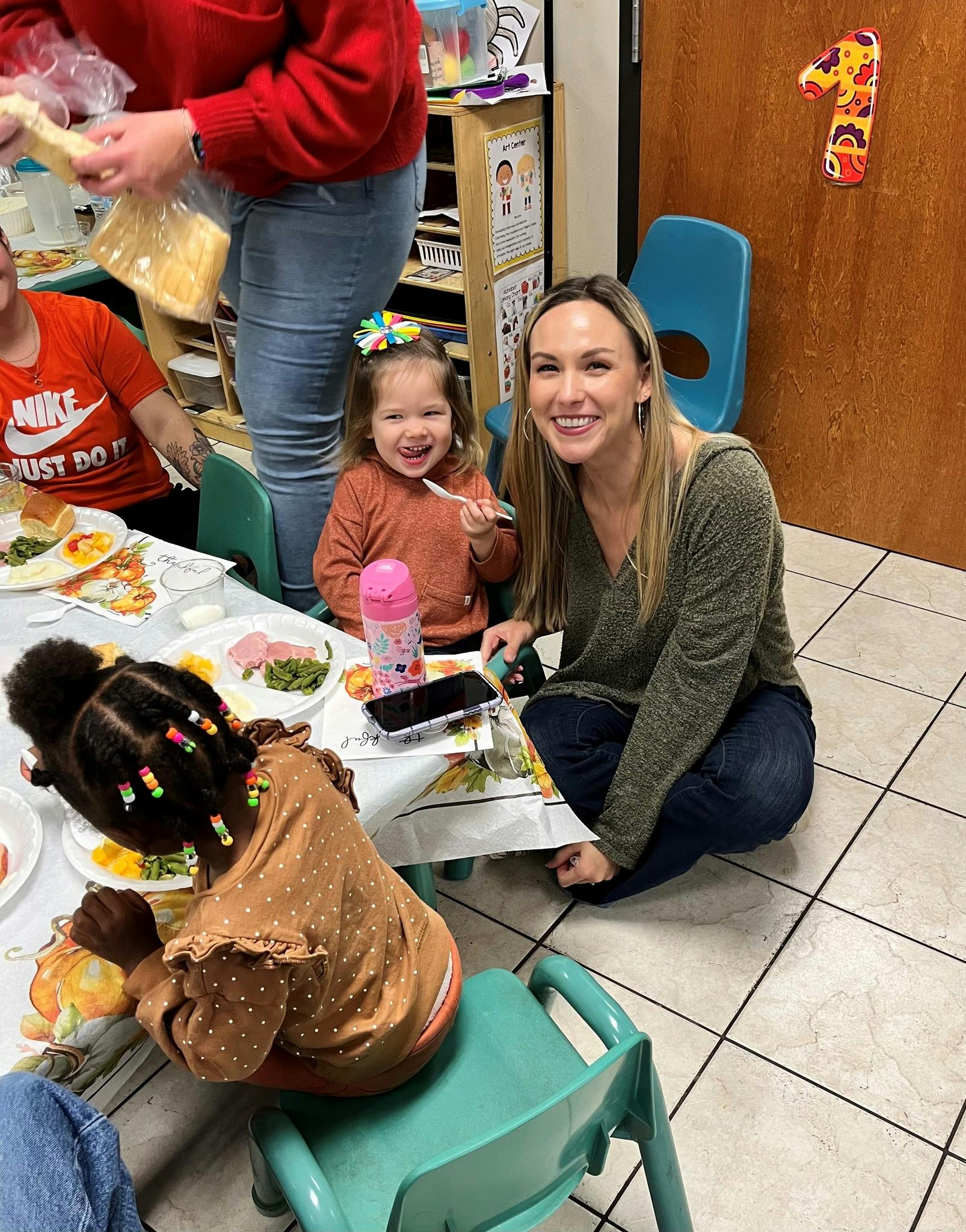Adult and child smiling at a table with other people eating