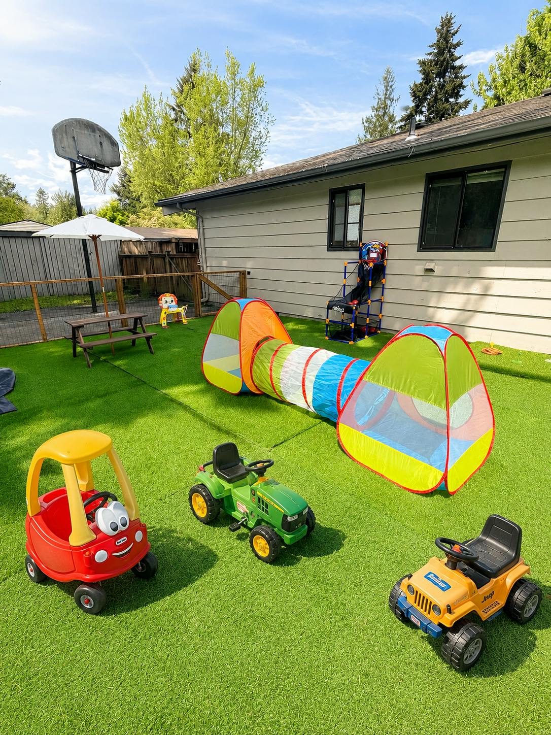 Play yard with a tunnel, toy cars, and a picnic table