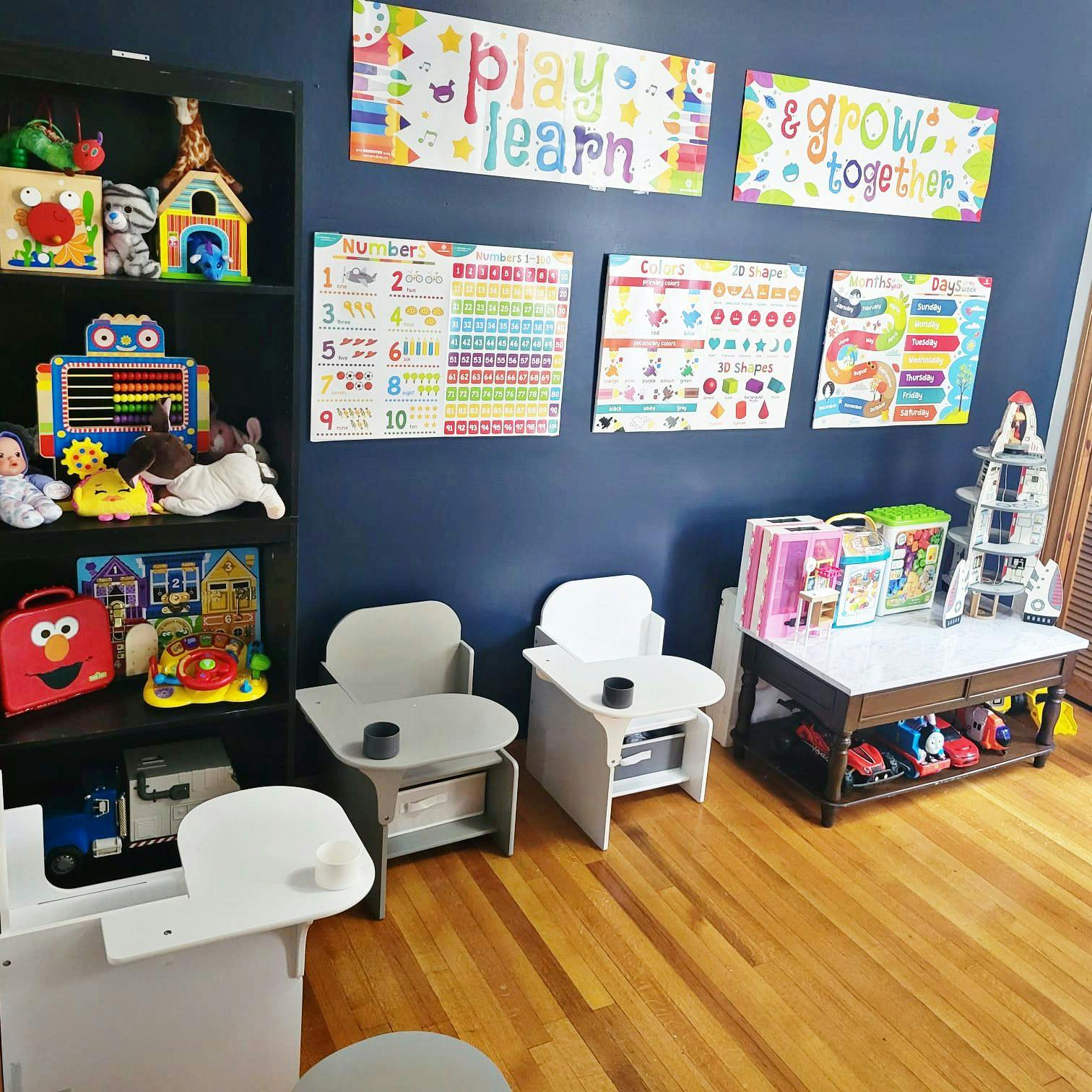 Playroom with educational posters, shelves of toys, and small chairs