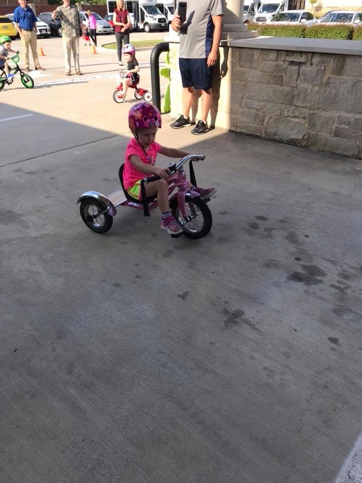 Child in a helmet riding a tricycle