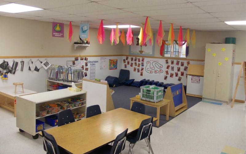 Empty classroom with colorful ceiling decorations and various learning stations