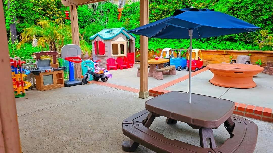 Plastic play equipment and tables on a backyard patio