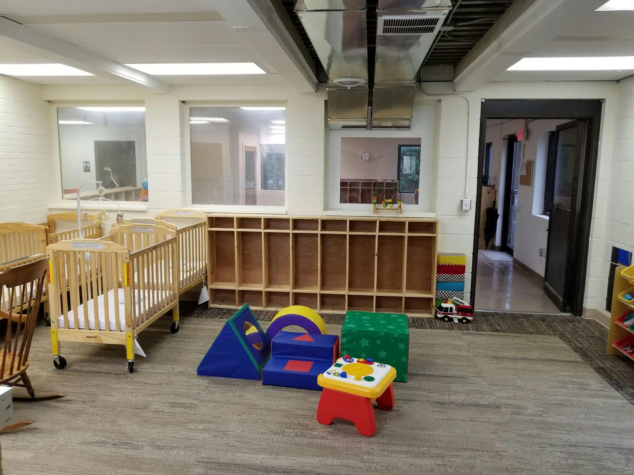 Cribs and soft play equipment in a room