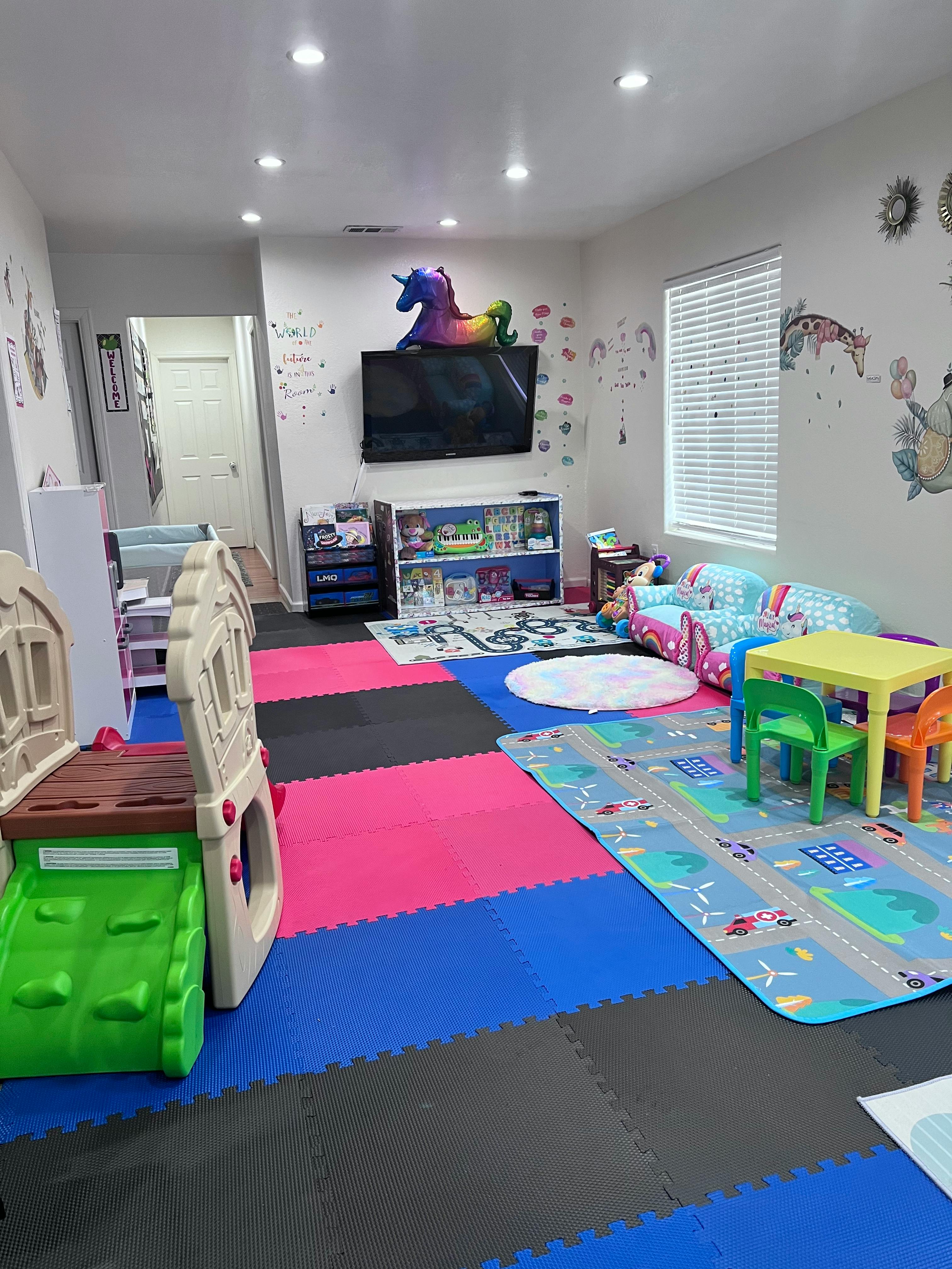 Playroom with colorful floor mats, small table and chairs, and a toy slide