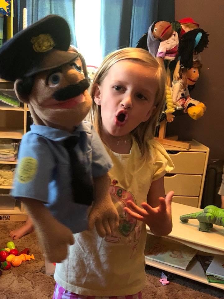 Child with a police officer puppet