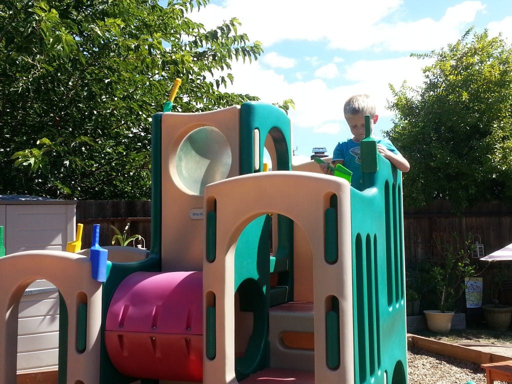 Child playing on a colorful outdoor play structure
