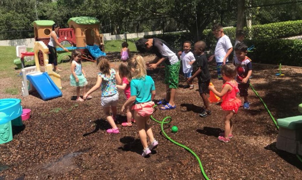 Adults and children playing outdoors with water and toys
