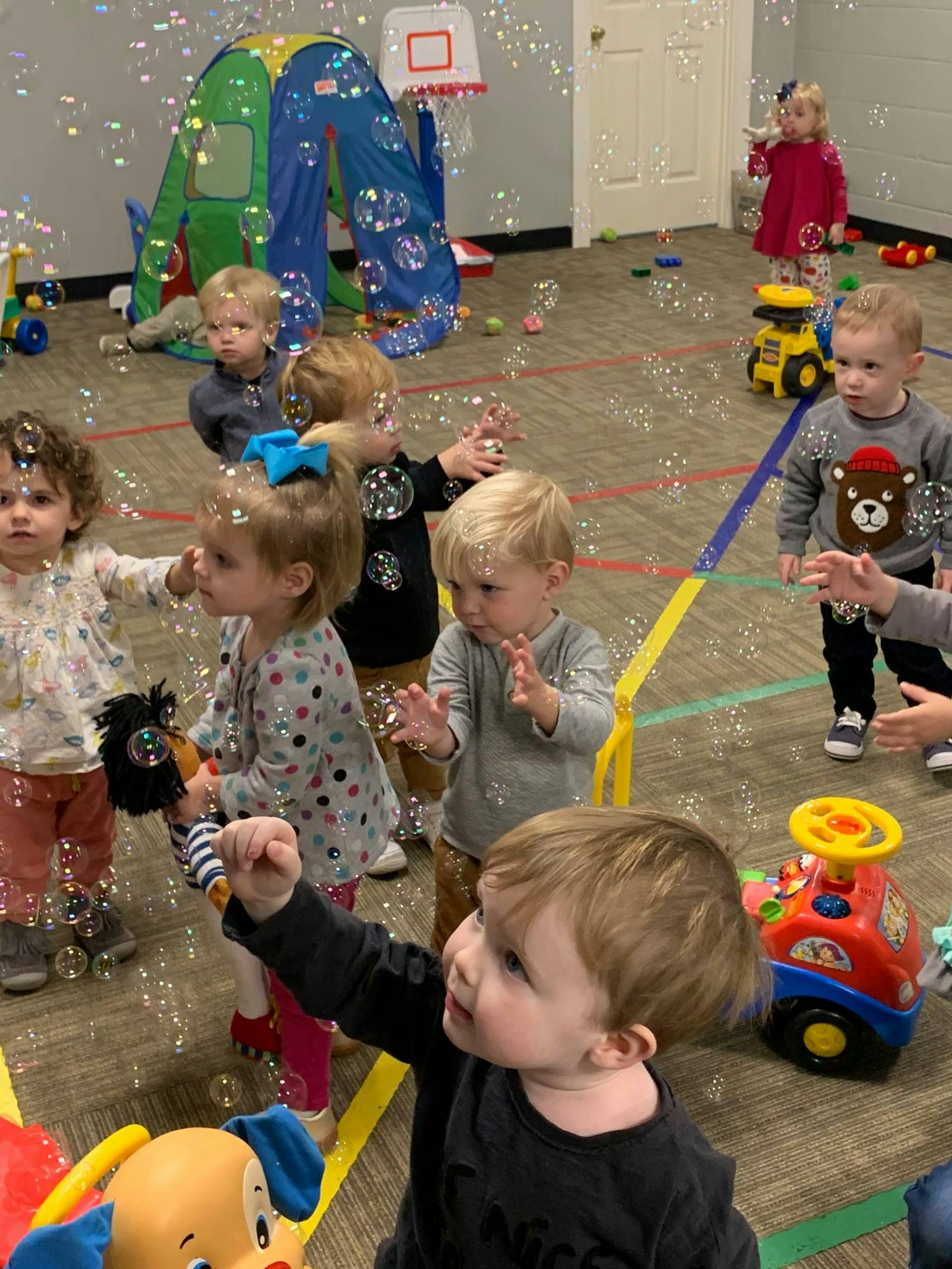 Children playing with bubbles in a room