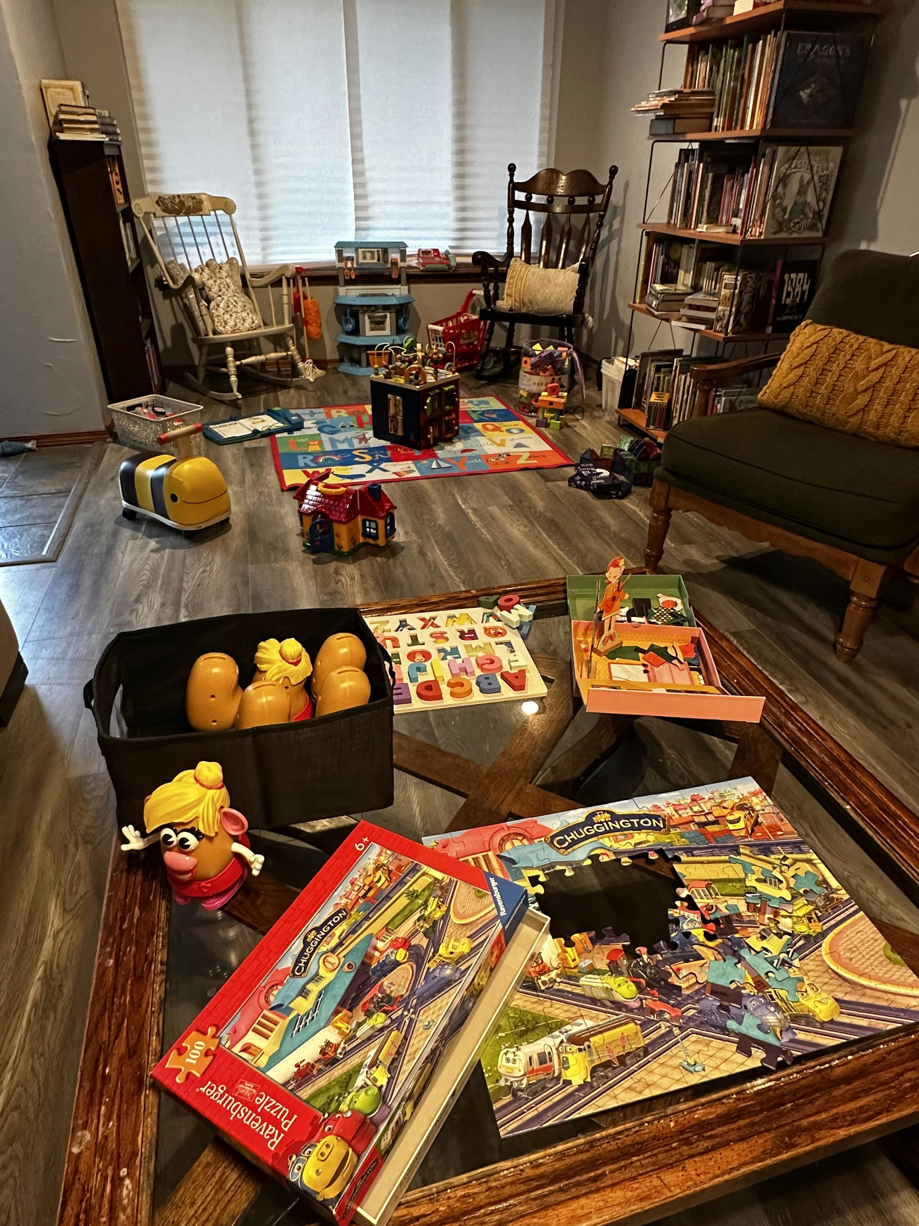 A room with various children's toys, including a ride-on bumblebee and puzzles
