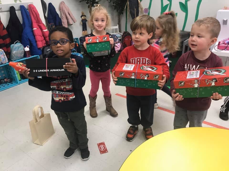 Children holding shoeboxes in a classroom