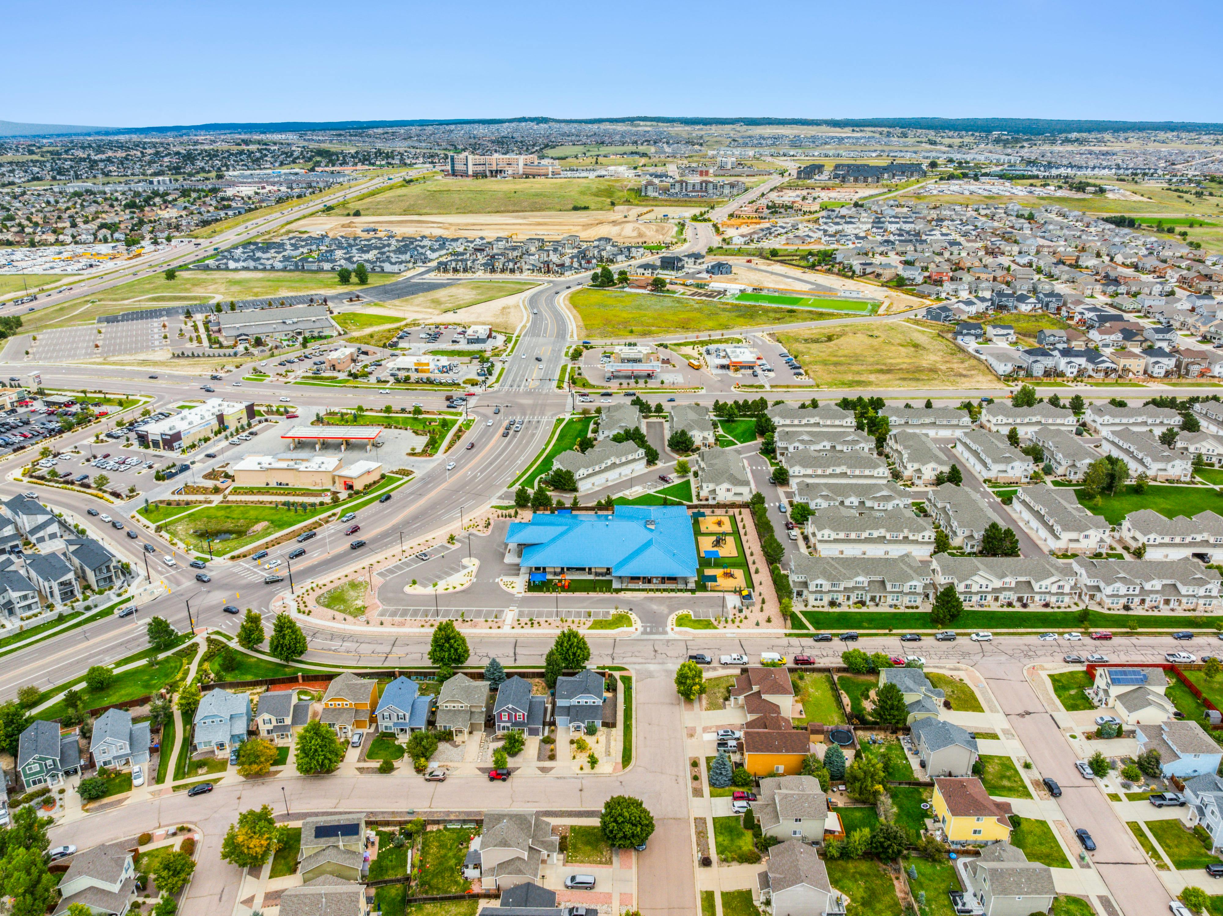 Aerial view of a sprawling suburban landscape with residential areas, roads, and commercial buildings