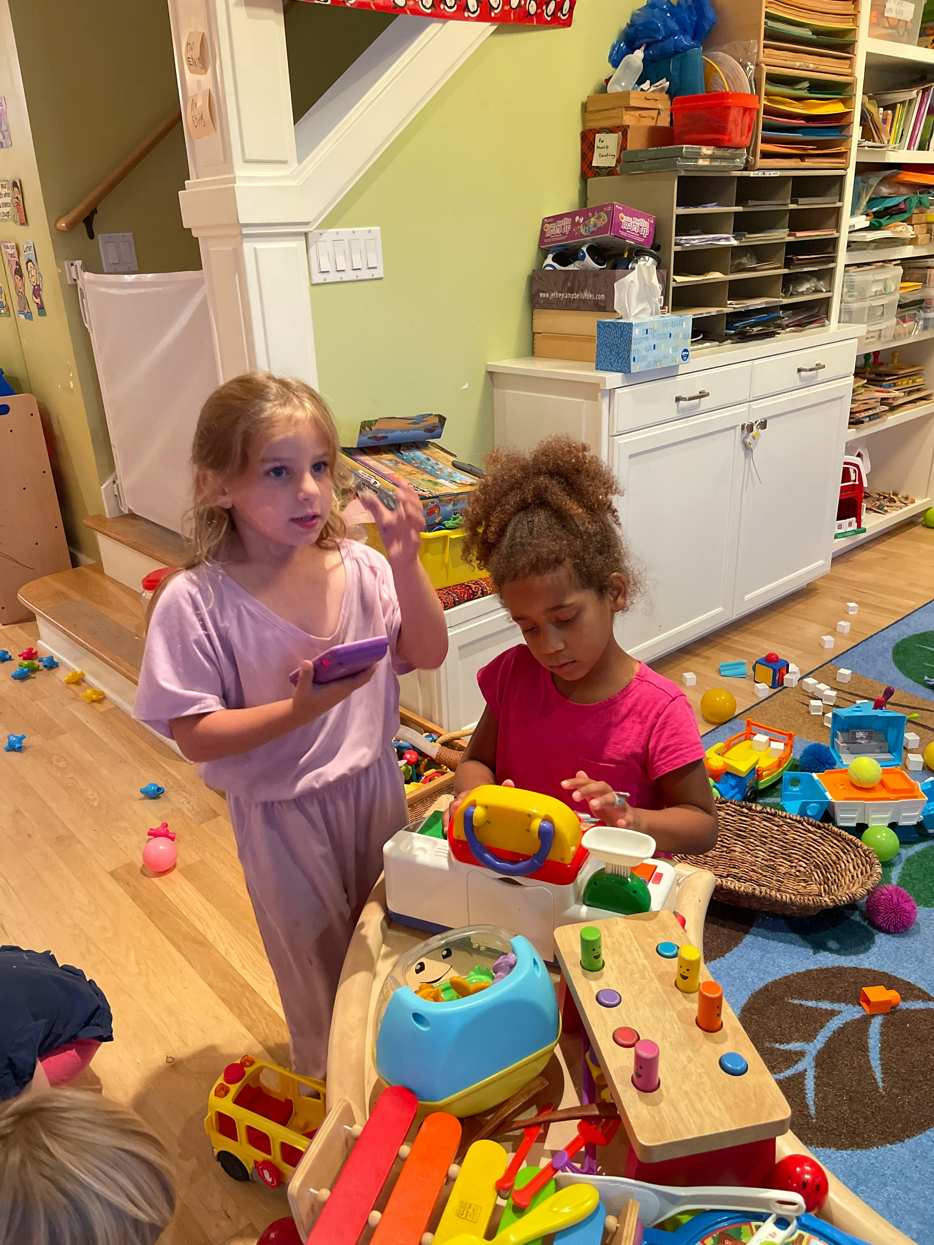 Two children playing with toys in a room