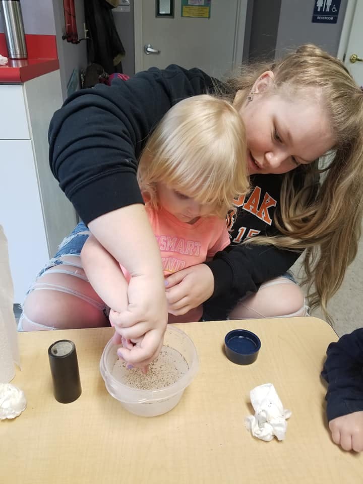 Person and child mixing contents in a bowl