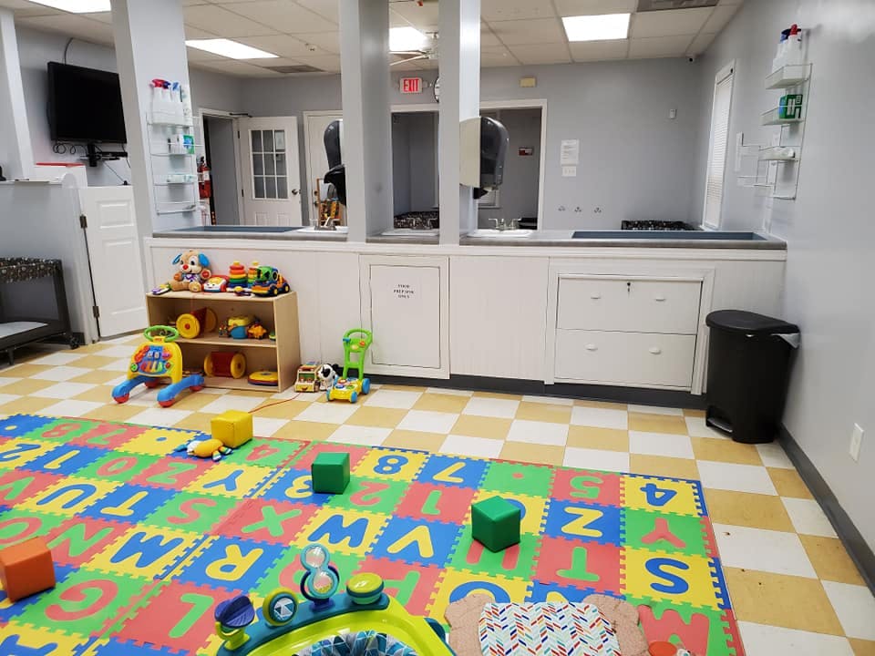 Playroom with alphabet mat and toys on a checkered floor