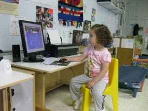 Child sitting at a desk using a computer