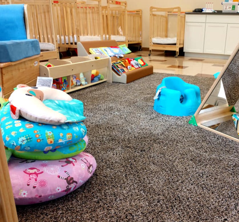 Nursery room with cribs, baby seats, and play items