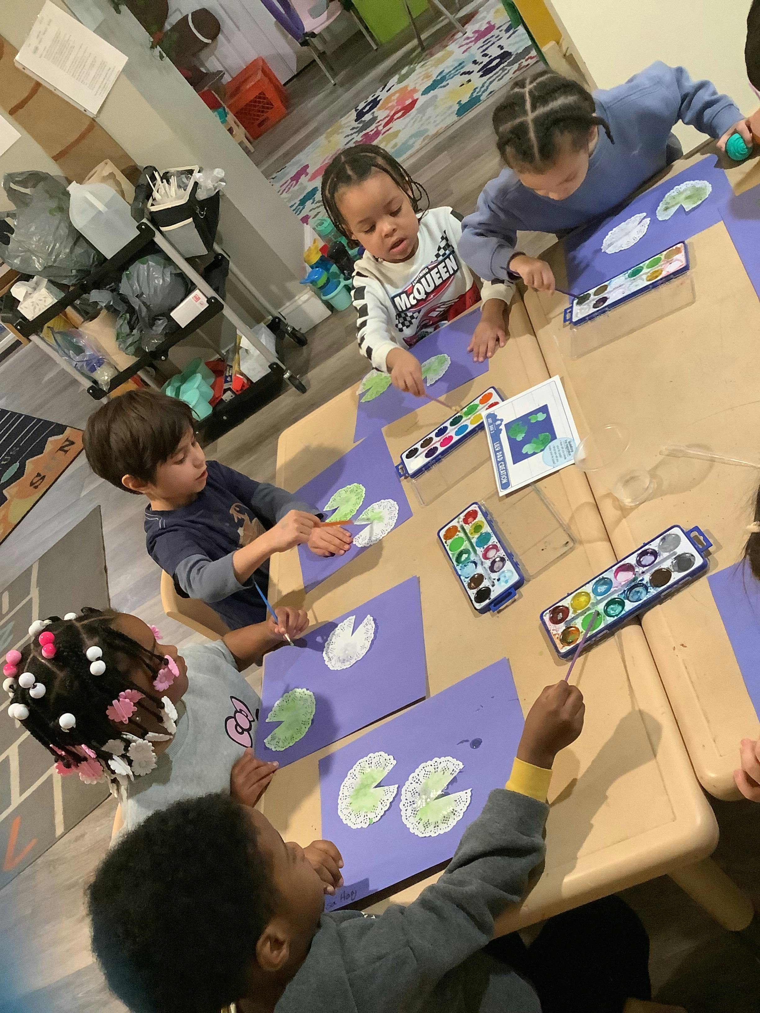 Group of children painting with watercolors at a craft table