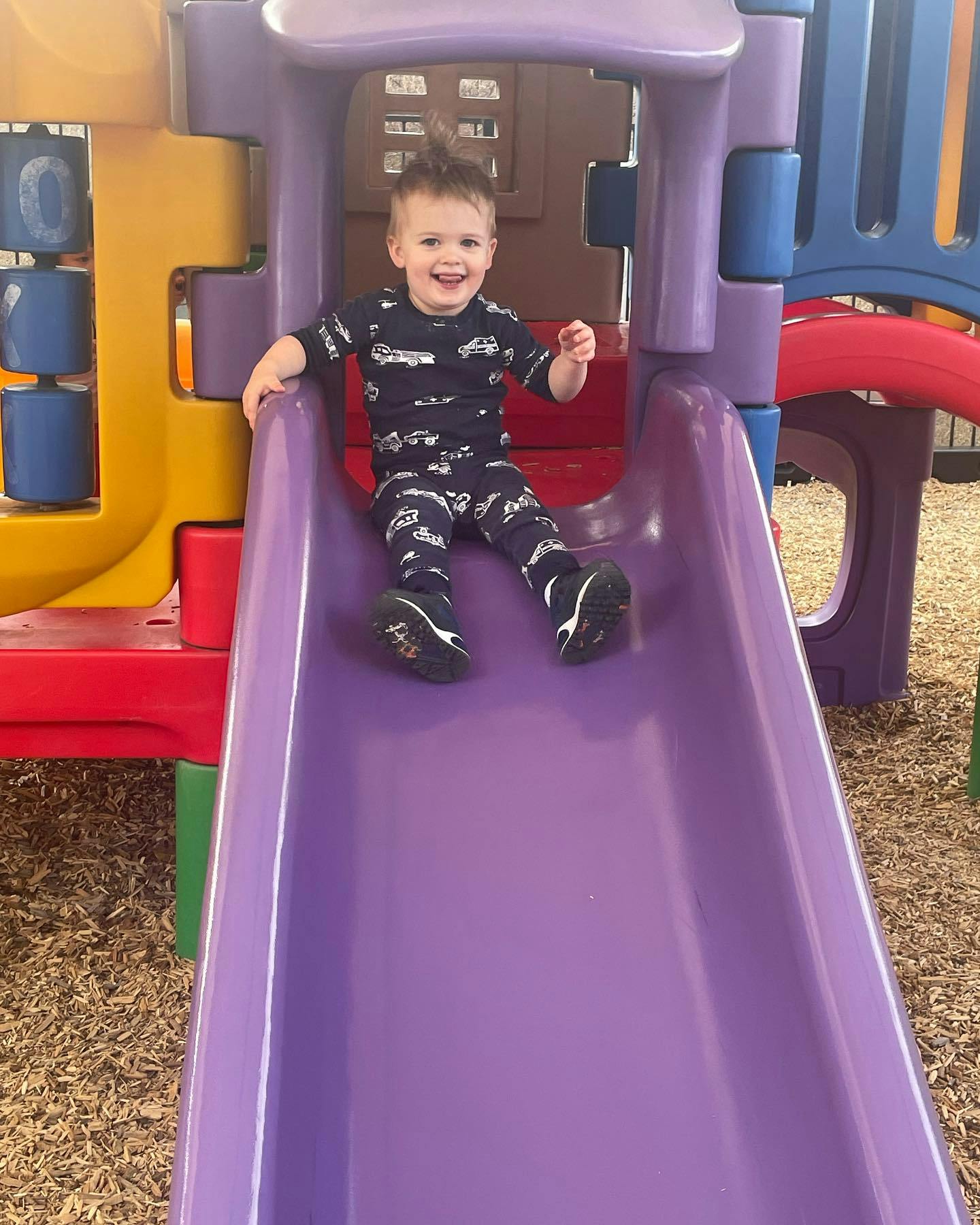 Child on a purple slide on a playground