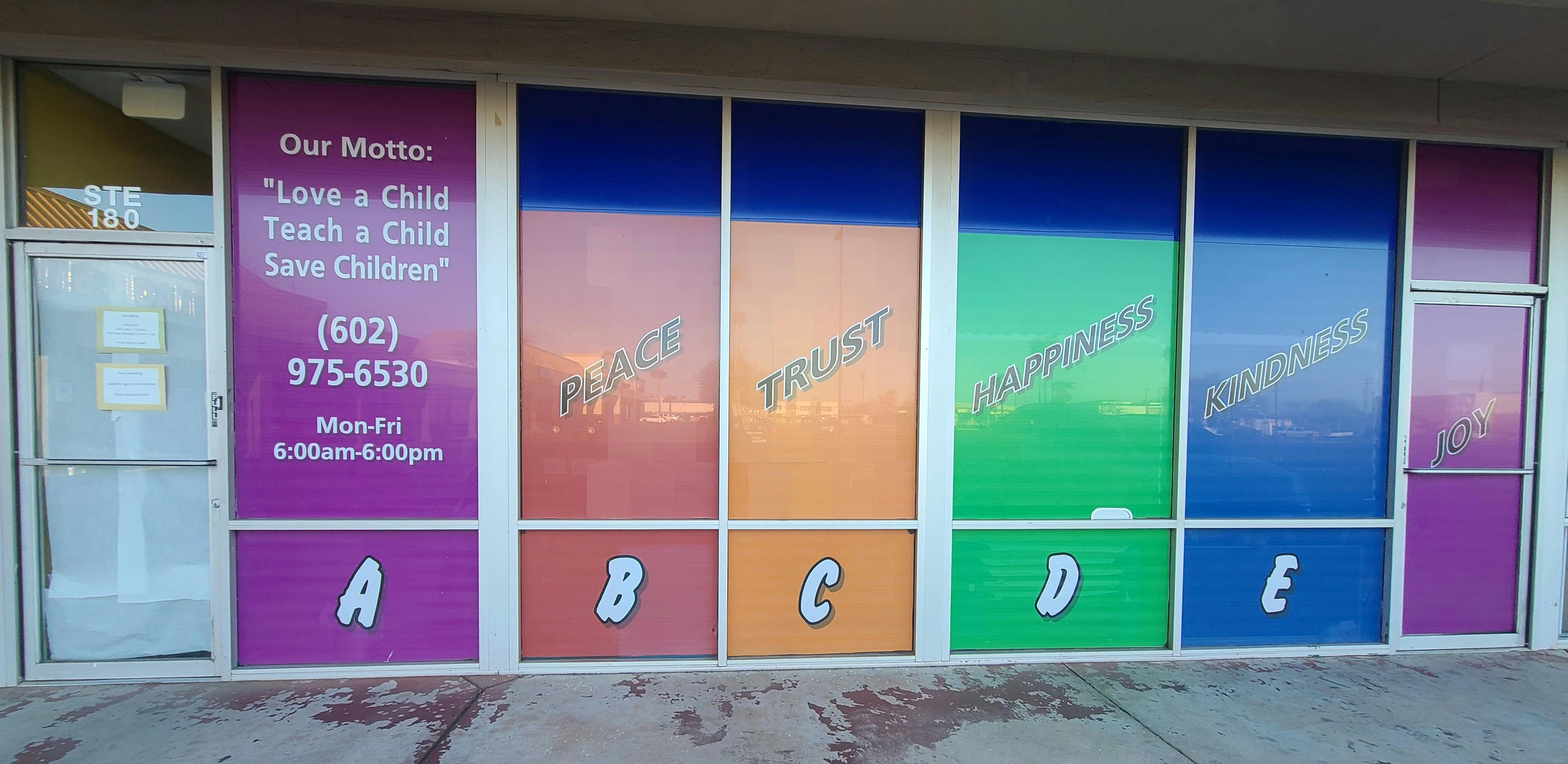 Storefront windows with colorful panels and text, including "Love a Child"