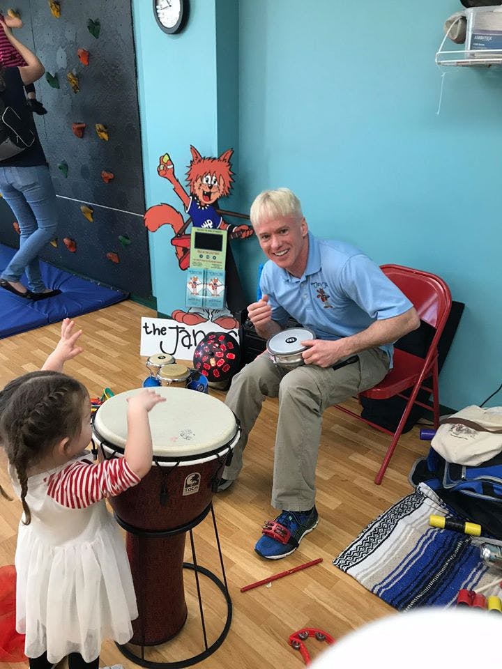 Adult and child playing drums and holding musical instruments