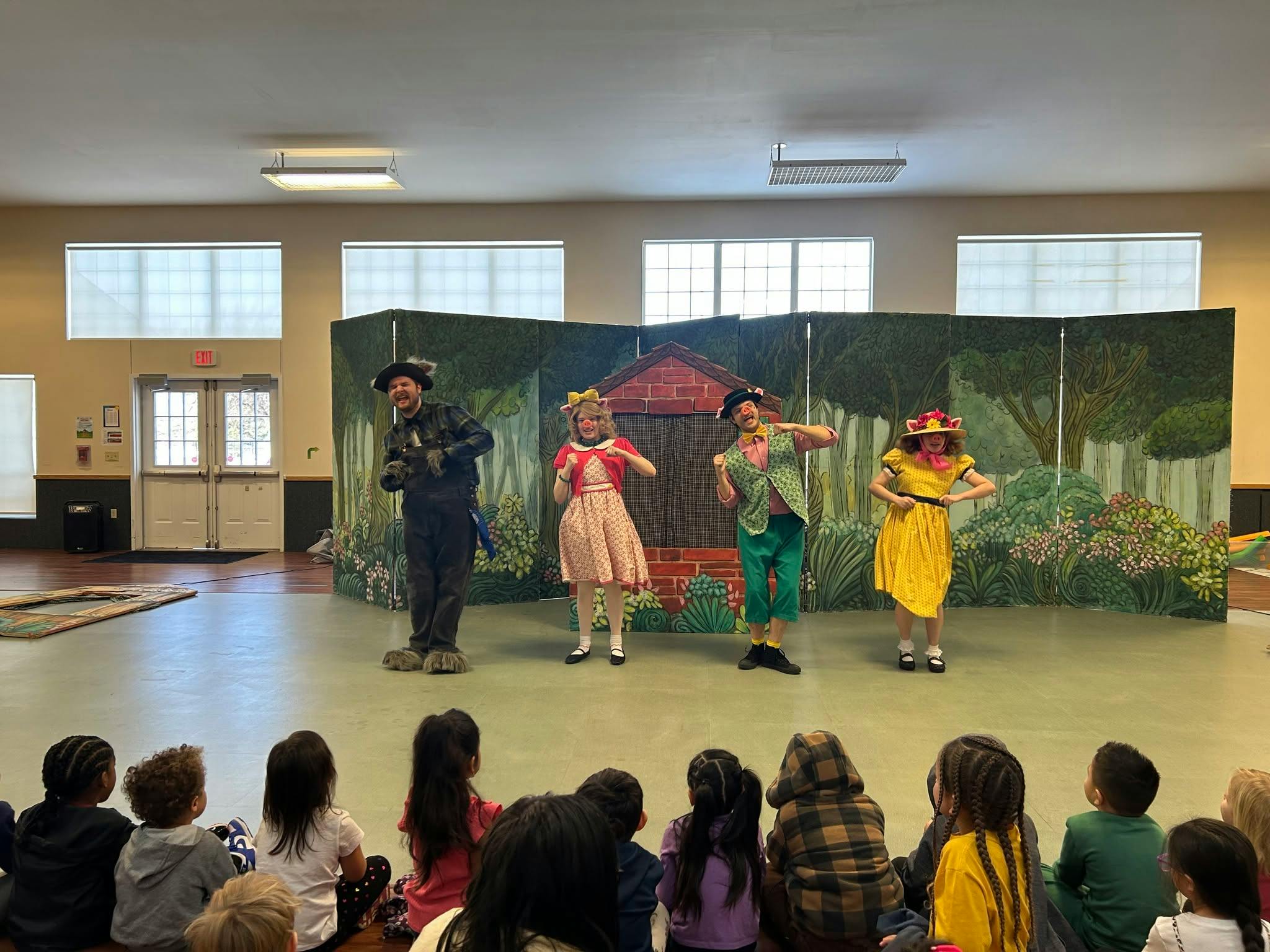 People in costumes performing a play for an audience of children