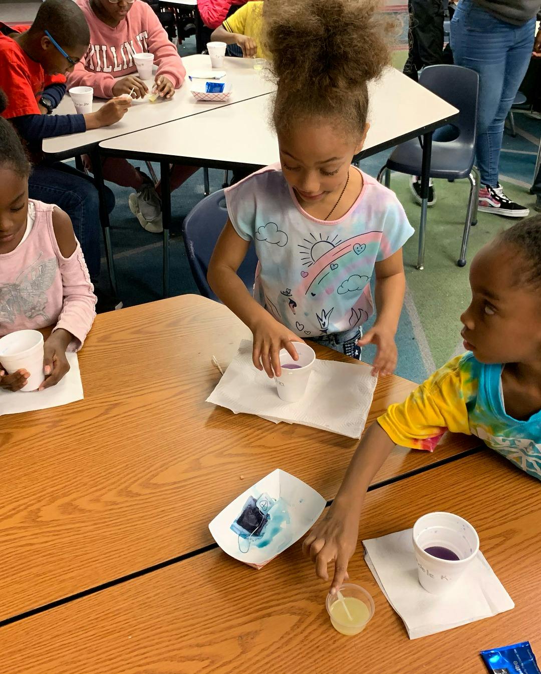 Children at a table with cups and craft supplies