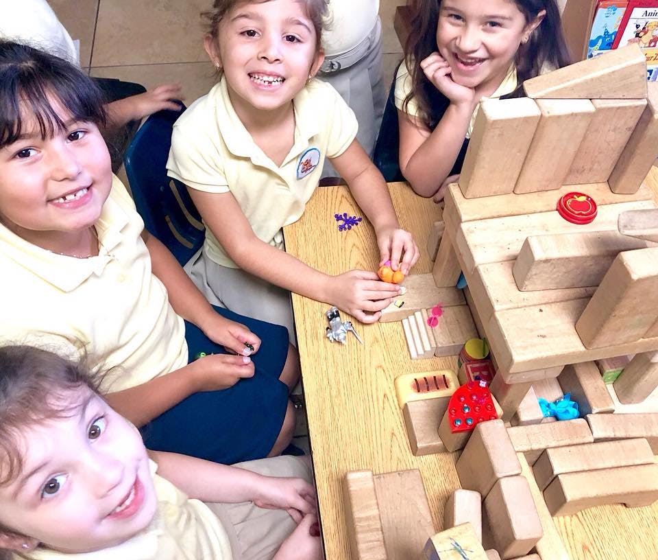 Children playing with wooden blocks at a table
