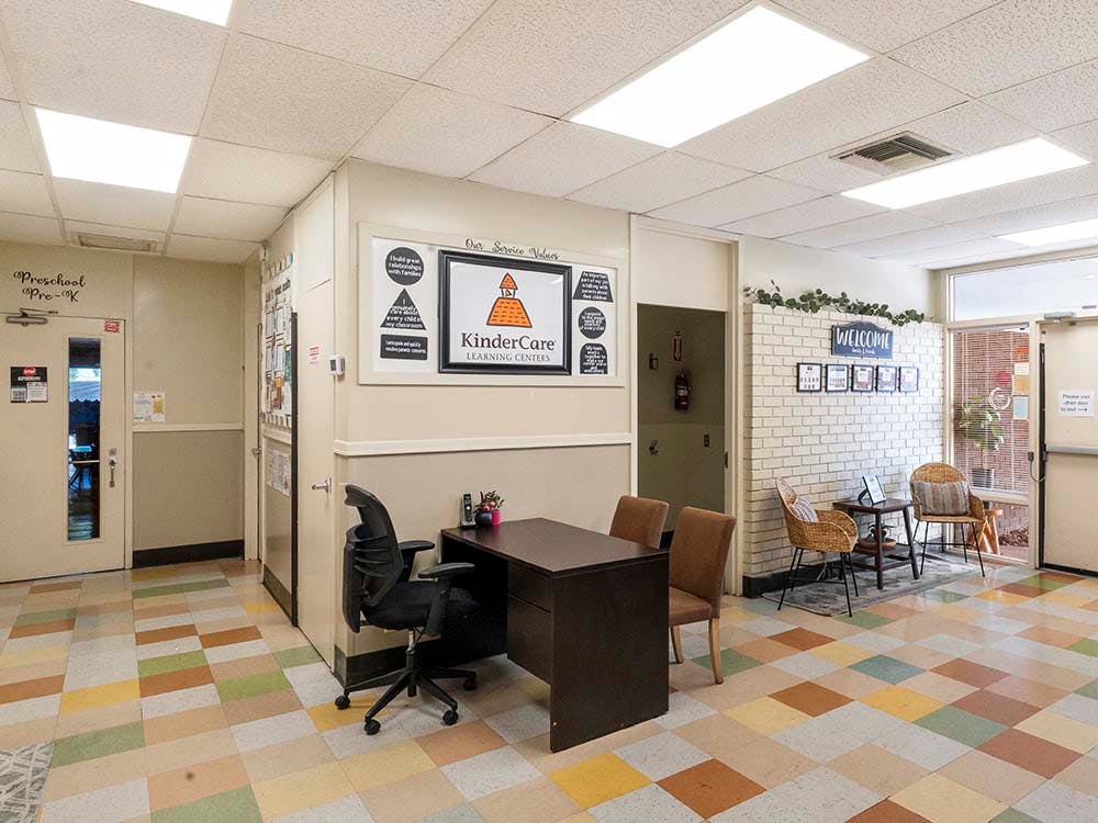 Reception area in a school with a desk, chair, and welcome sign