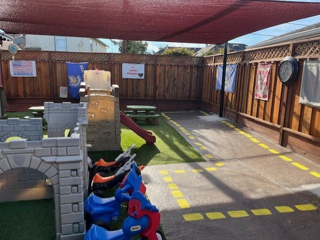 Outdoor play area with toy castle, slide, and ride-on toys