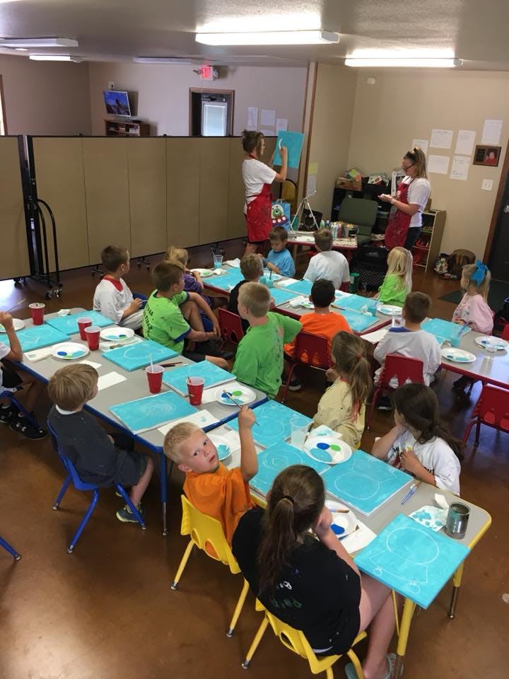 Adults teaching children in a classroom setting