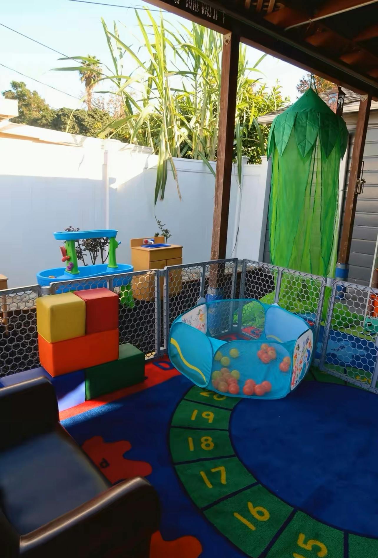 An outdoor play area with a ball pit, soft blocks, and a water table